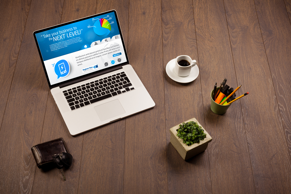 Laptop on office wooden desk with business website on screen