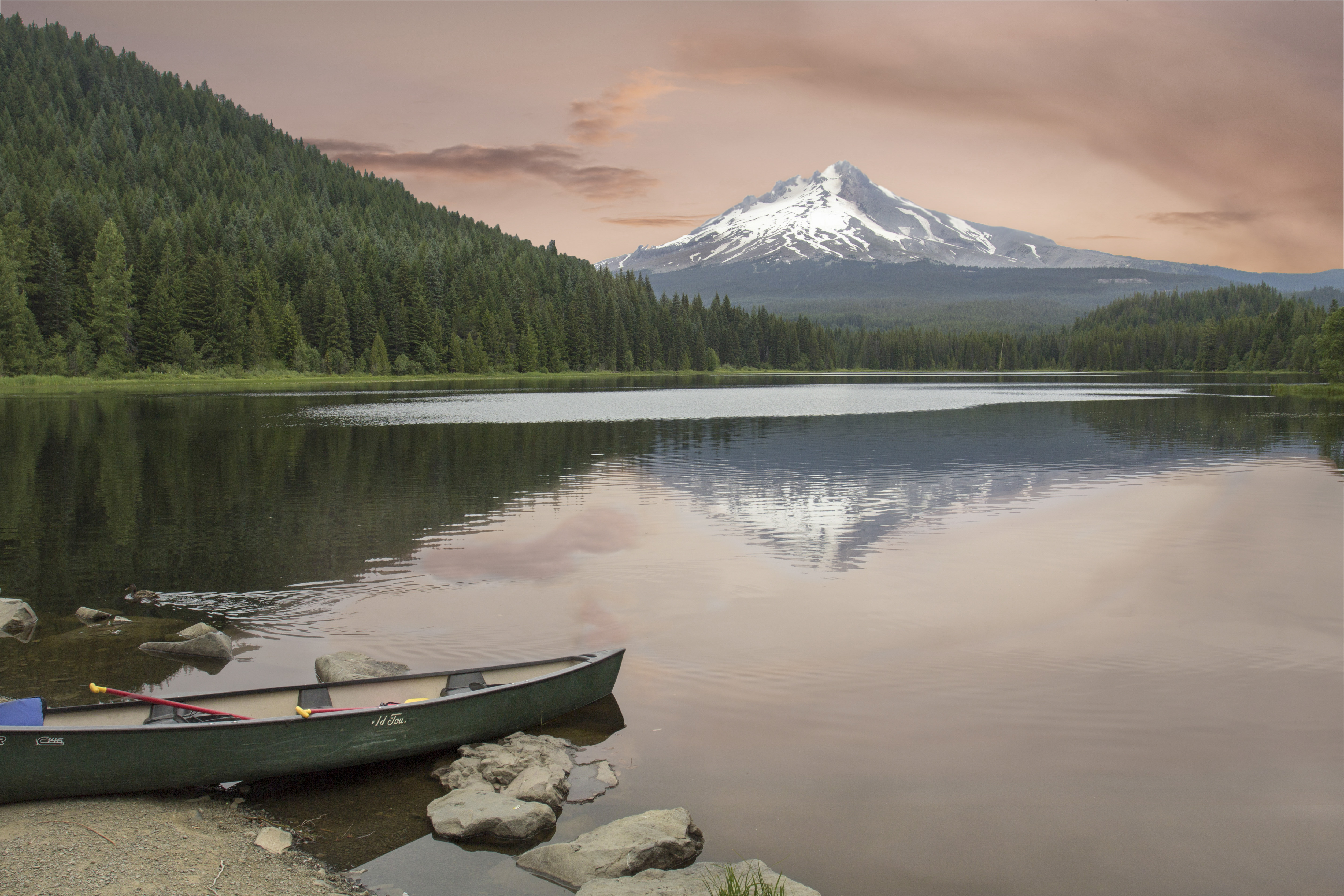 Visual of scenic lake with canoe in foreground and whitecapped mountain in background metaphorically representing Snowflake Data Lake